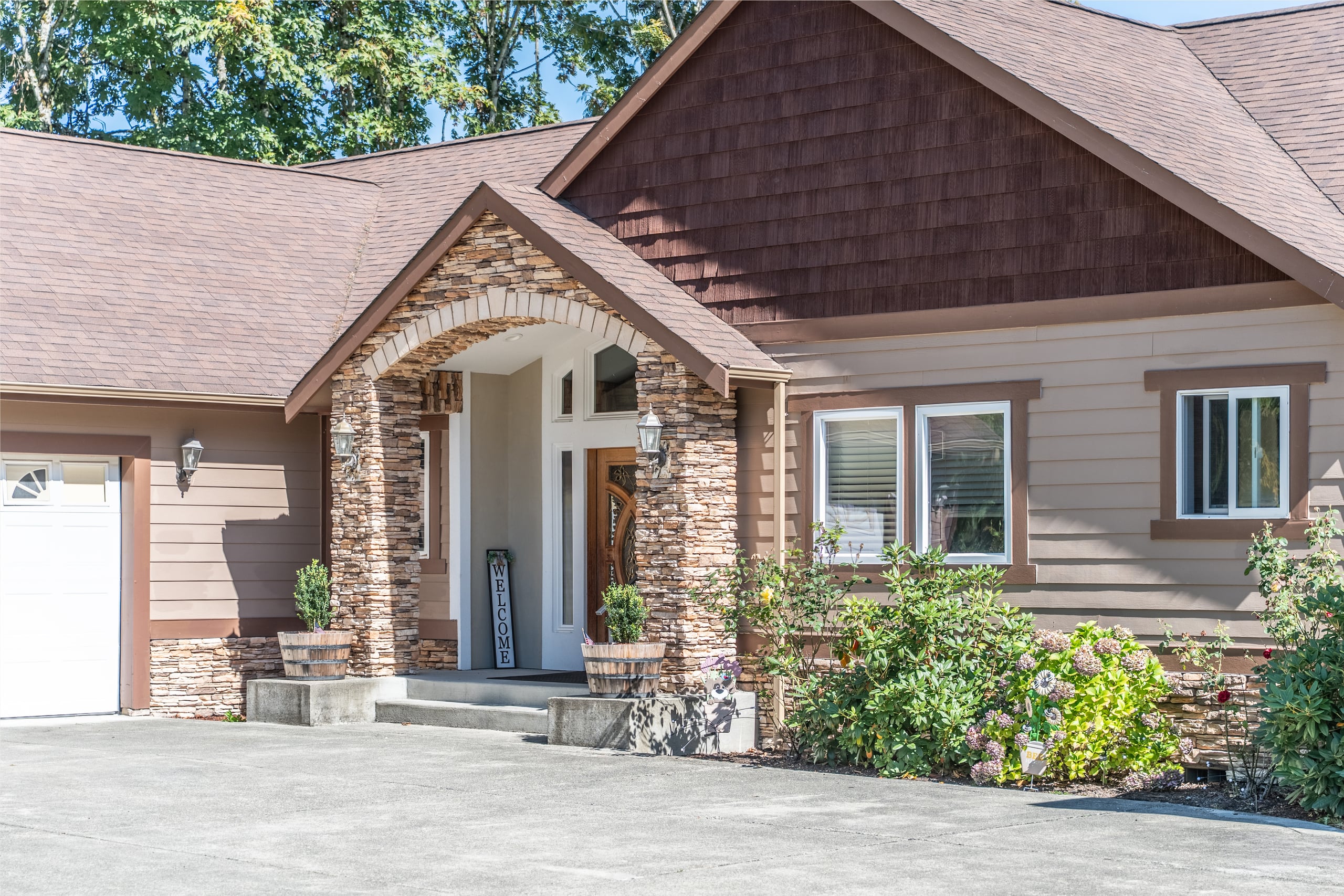 The covered stone entry and leaded-glass front doors of the home.