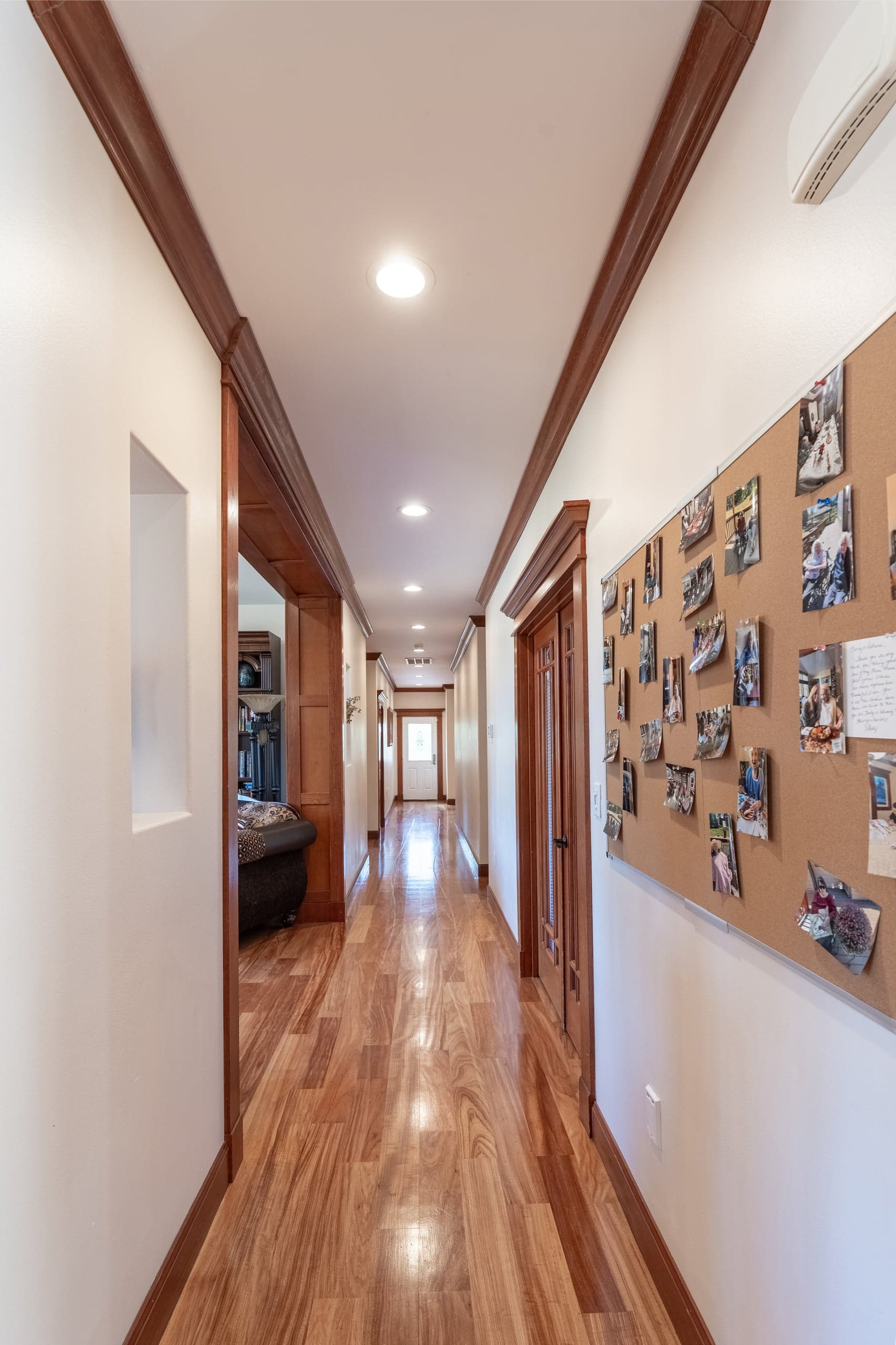 A wide hallway with cherry wood trim, easily accessible by wheelchair.